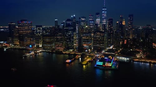Approaching one of the multiple piers of New York with neon illumination from above the river.