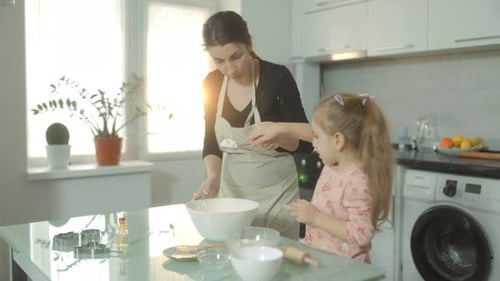 Mother and Daughter Baking Cookies in Kitchen
