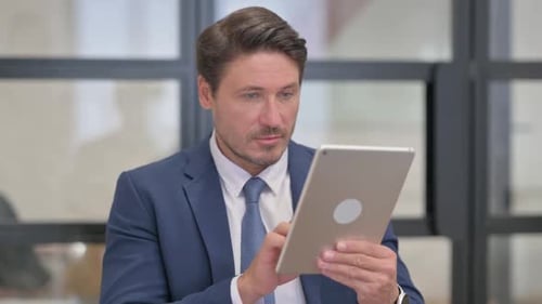 Man in Suit Using Tablet in Office