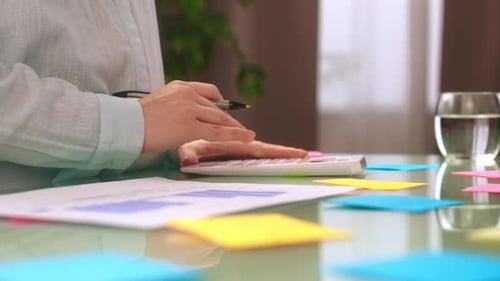 Pessoa analisando dados financeiros com calculadora e gráficos