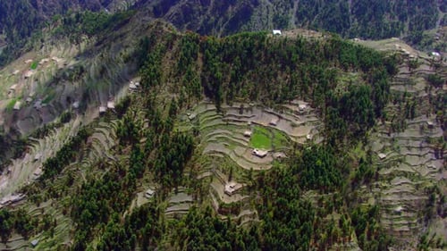 Rotational aerial view of the green beautiful valley between the mountains having river and roads an
