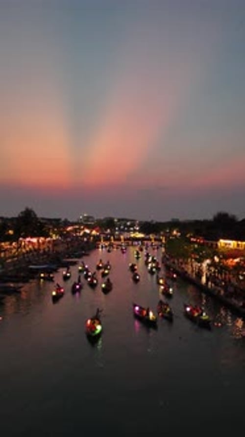 Magnifique coucher de soleil aérien au-dessus de bateaux-lanternes remplis de touristes lors de la magnifique fête des lanternes de Hoi An
