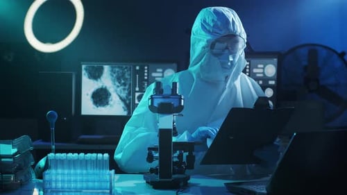 Scientist Examines Microscope Samples in Dark Laboratory