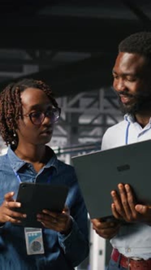 Vertical Video Data Center Coworkers Doing Maintenance Tasks on Laptop