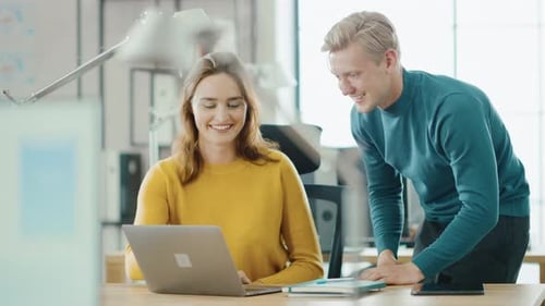 Business Colleagues Discussing Work at Desk on Laptop