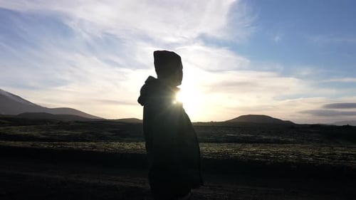 Silhouettierte Figur bei wunderschönem Sonnenuntergang am Krater