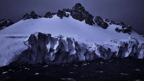 Powerful Image of Icy Terrain Under Ominous Cloudy Sky and Turbulent Sea