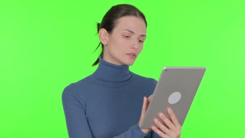 Beautiful Woman Celebrating Success on Tablet on Green Background