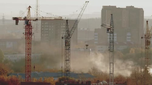 Construction Cranes Against City Skyline During the Day