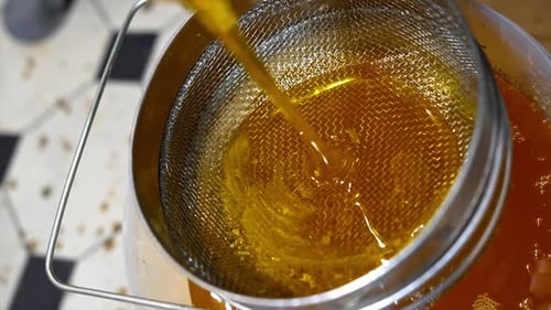 Liquid Poured Through Strainer into a Container