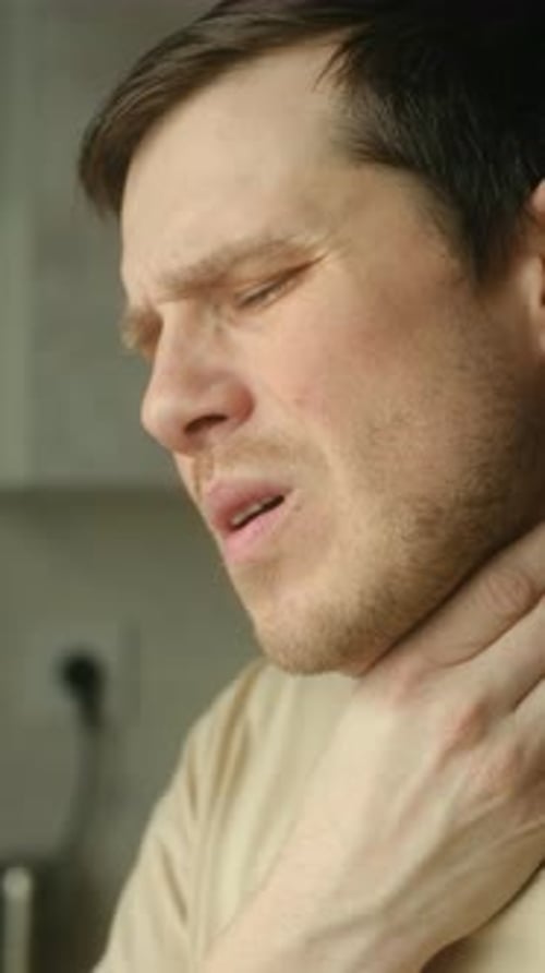 Man with a Sore Throat Holds His Neck