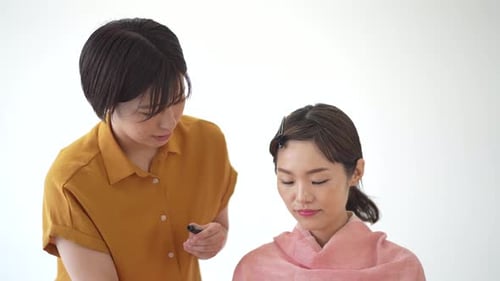 Makeup Artist Applying Mascara to a Woman's Eyelashes