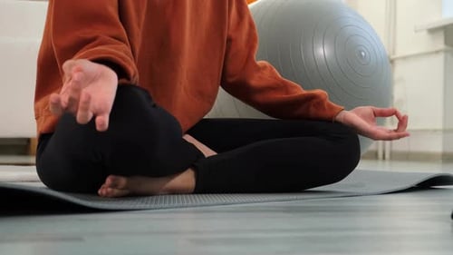 Person Meditating on Yoga Mat at Home
