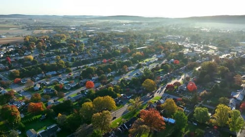 American suburb during autumn sunrise. High aerial establishing shot in USA town.