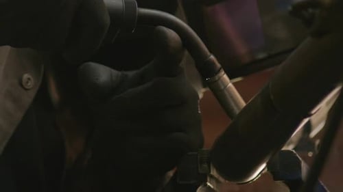 Expert mechanic showcases their welding skills in their workshop, while wearing full protective gear