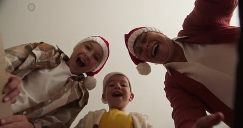 Excited Family Opening Christmas Box from Low Angle