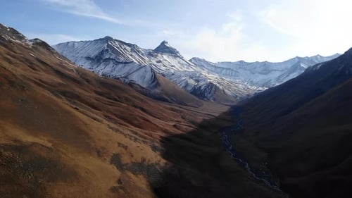 Cinematic Aerial Perspective Capturing Snowtopped Peaks And Golden Slopes In Mountain Valley Media