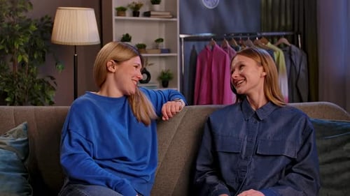 Women Talking and Laughing on Sofa Indoors