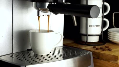 Espresso machine pouring fresh coffee inside white cup