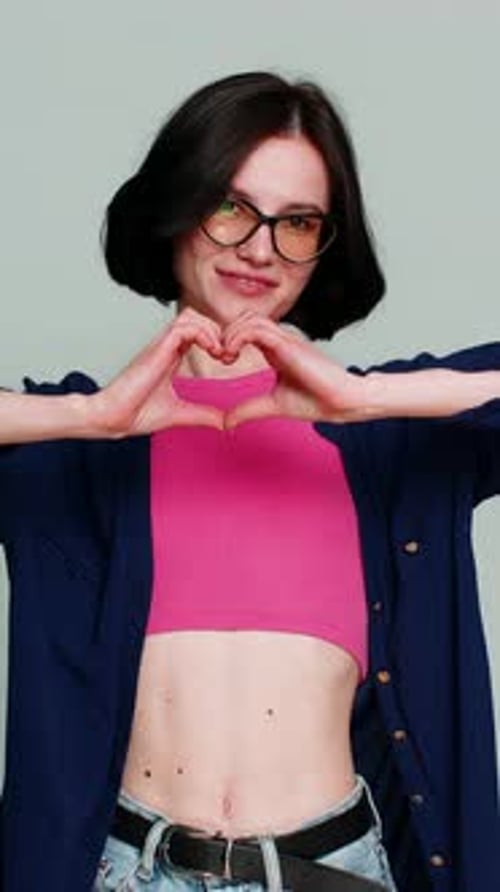 Young Woman Makes Heart Shape With Hands