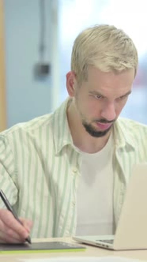 Man Using Graphic Tablet and Laptop at Desk