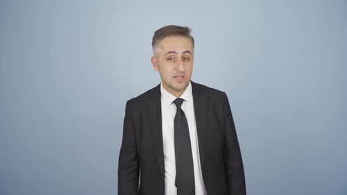 Man in Suit Speaking with Displeased Expression