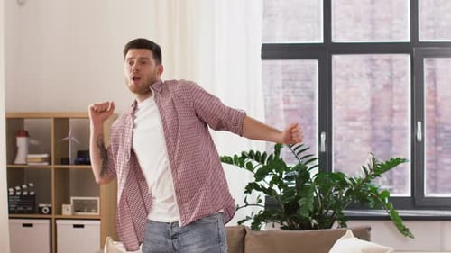 People and Fun Concept - Happy Smiling Young Man Dancing at Home Adult