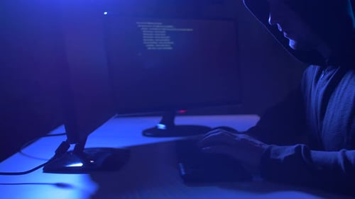 Cybercrime, Hacking and Technology Concept - Male Hacker in Dark Room Writing