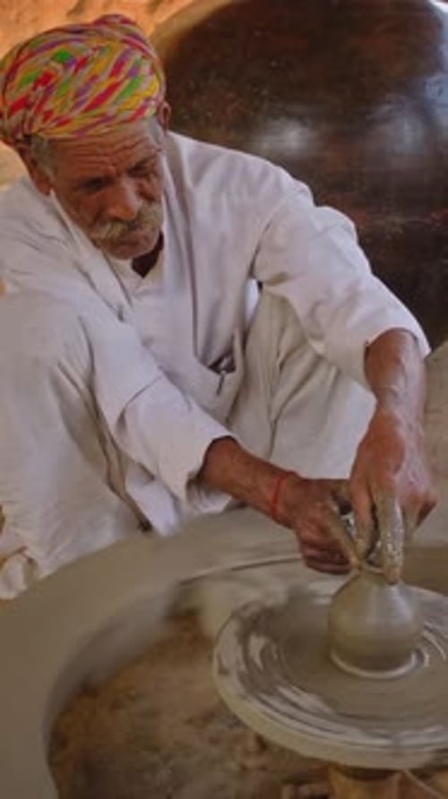 Potier jetant le tour de potier et façonnant un pot dans un atelier de poterie