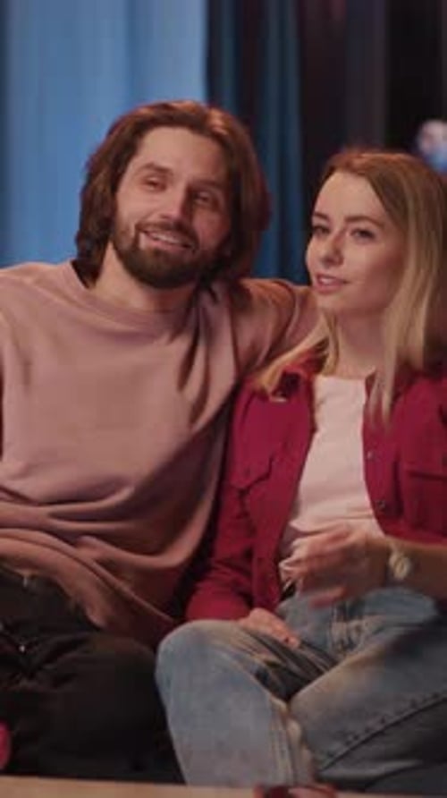 Lovely Caucasian Young Couple of Man and Woman Dating in Apartment Watching Horror Movie on