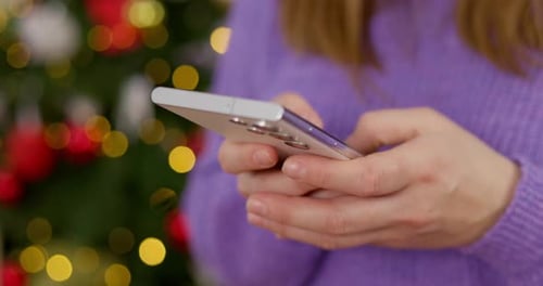 Closeup of Hands Using Smartphone During Holidays
