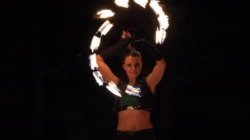 Woman Performs Fire Dance in Dark Setting