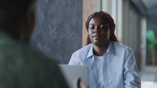 Professional Afro American Duo Leading Business Meeting in Cafe While Enjoying Coffee and Using