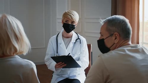 Doctor Talks to Elderly Patients During a Medical Consultation in an Office Setting