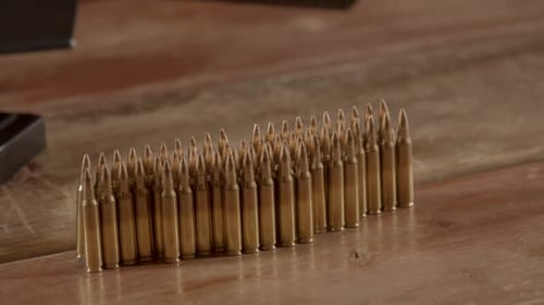 Dolly of .223 ammunition on a wooden surface next to a black AR-15 magazine