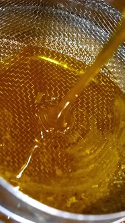 Shiny Brown Liquid Being Poured and Filtered