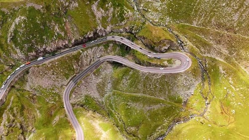 Winding mountain road scenery. Cars navigate a winding road surrounded