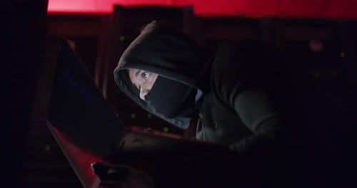 Hooded Hacker Working on Computer in Server Room