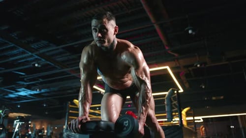 A Man is Doing Dumbbell Rows at the Gym Focusing on Strength and Conditioning in His Workout