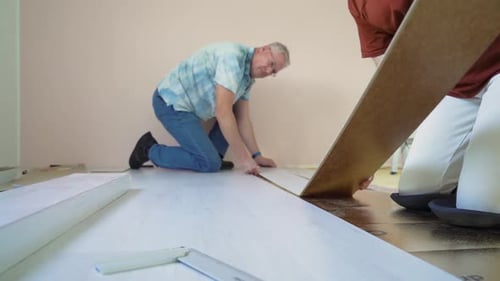 Adults Laying New Laminate Flooring at Home