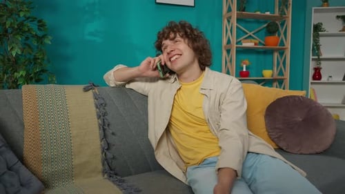 Cheerful Young Adult Chatting on Phone at Home