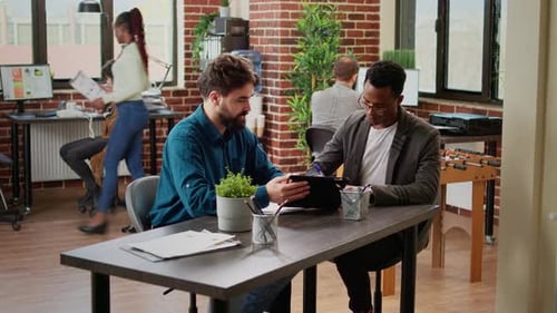 Men Collaborate on Tablet in Modern Office
