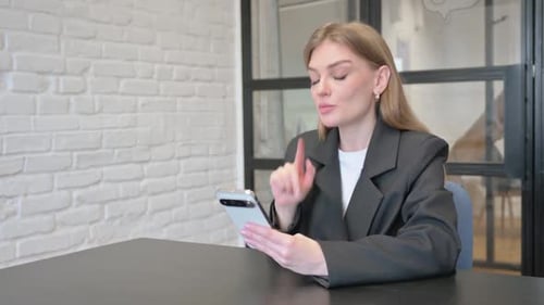 Businesswoman Doing Video Chat on Phone in Office