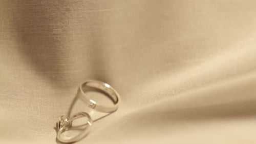 Two Gold Rings for engagement.dropped on a velvet cloth. Wedding Jewelry.