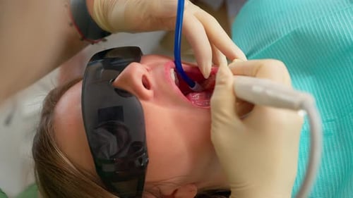Dentist Doing Teeth Cleaning Procedure with Special Tool in Dental Clinic