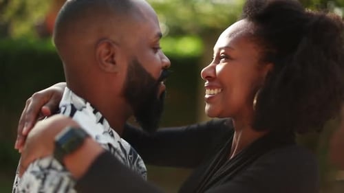 Affectionate Couple Embracing and Smiling Outdoors in Sunlight