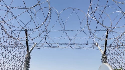Barbed Wire at Prison Gate Exit | Slow Move Towards Opening as Birds Fly