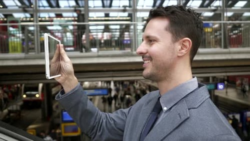 Young Adult Man Uses Tablet on Escalator
