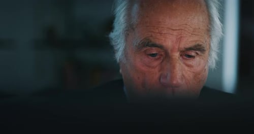 Senior Man Concentrating, Reading at Night