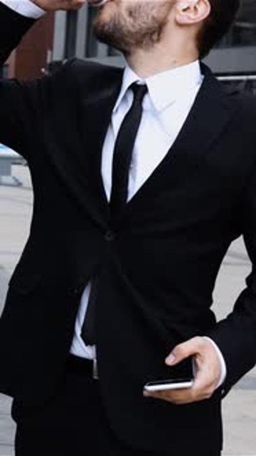 Vertical of Boss Talking on Mobile Cell Phone in City Coffee Break